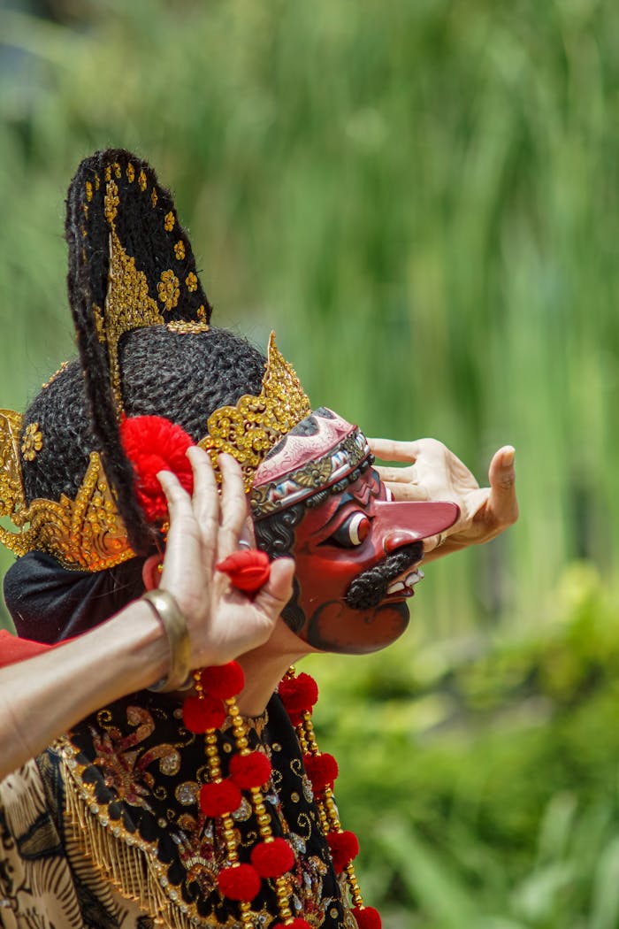 Vibrant close-up of traditional Indonesian dance costume and mask outdoors.